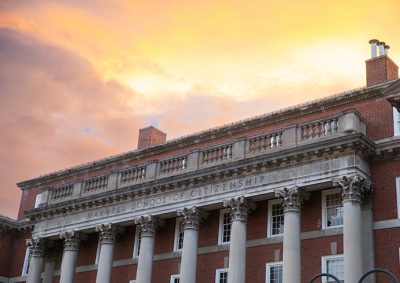 Maxwell School building with brightly lit clouds in the background