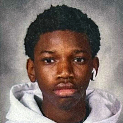 A student poses for a headshot in front of a grey backdrop.