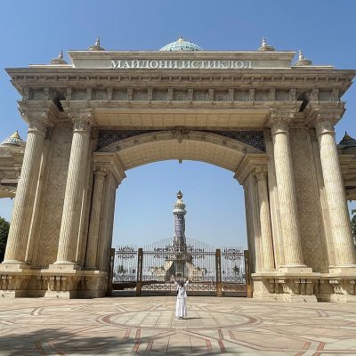 Woman in white in front of a gate