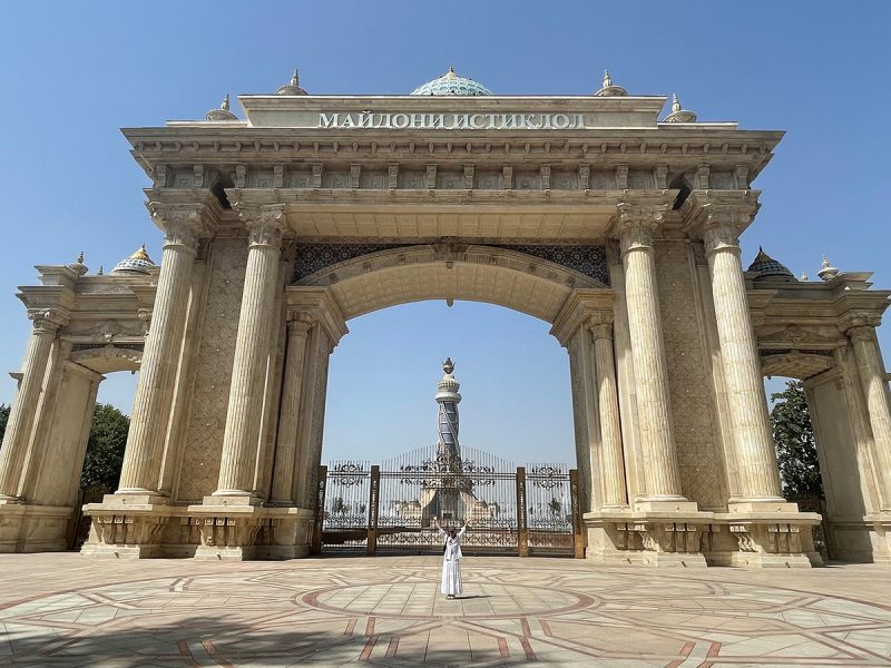 Woman in white in front of a gate