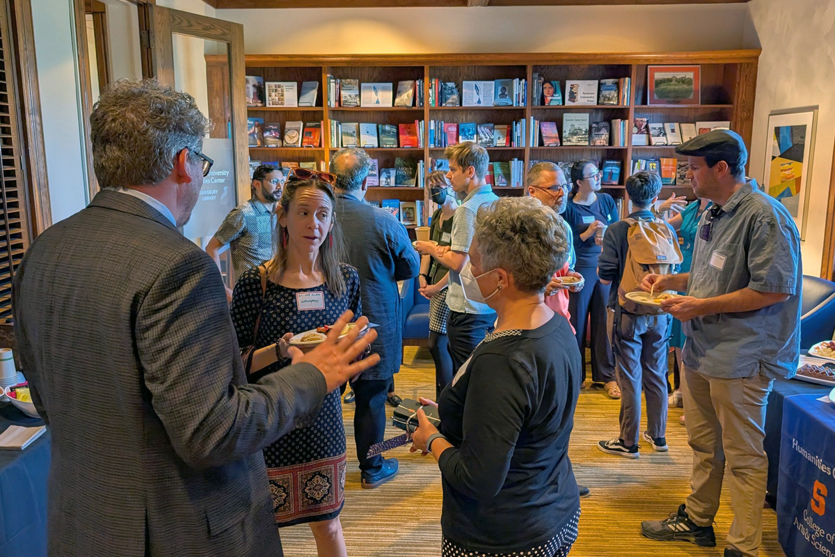 Members of the campus community mingling and talking in a building on campus.