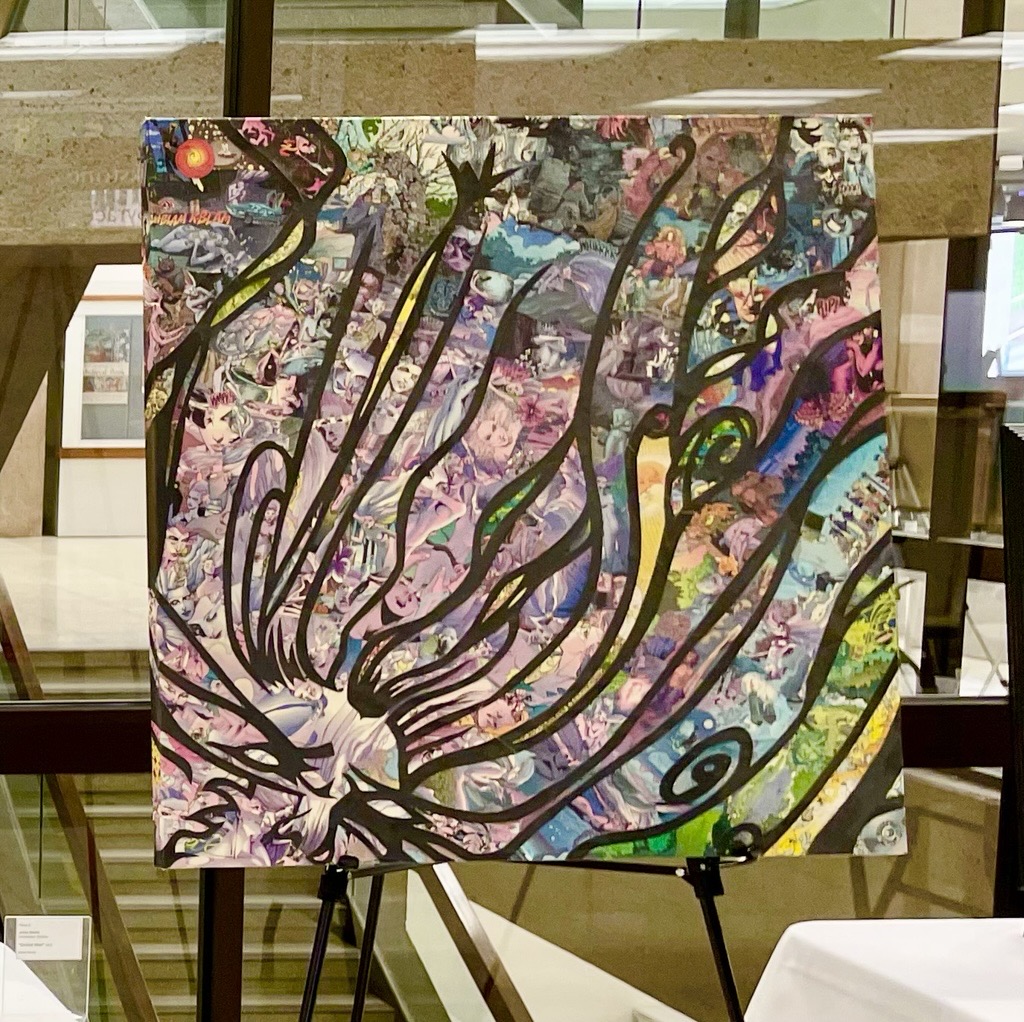 Colorful collage artwork with bold black abstract lines on an easel, set in a modern space with glass windows.