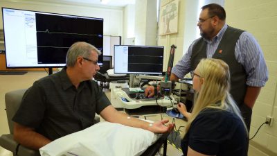 Subject is having nerve conduction testing done by professor and student
