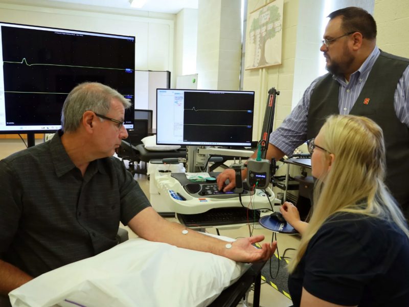Subject is having nerve conduction testing done by professor and student