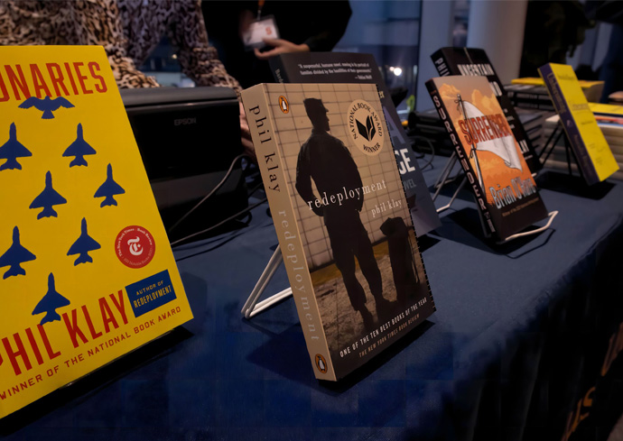 Display of books on stands on a table with a dark tablecloth, including 'Redeployment' and 'Missionaries' by Phil Klay