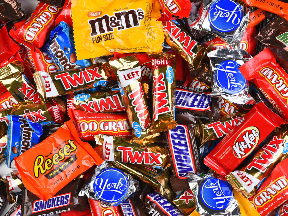 Assorted fun-size Halloween candy including M&Ms, Twix, Snickers, Kit Kat, Reese's, Milky Way and York Peppermint Patties in a colorful pile.