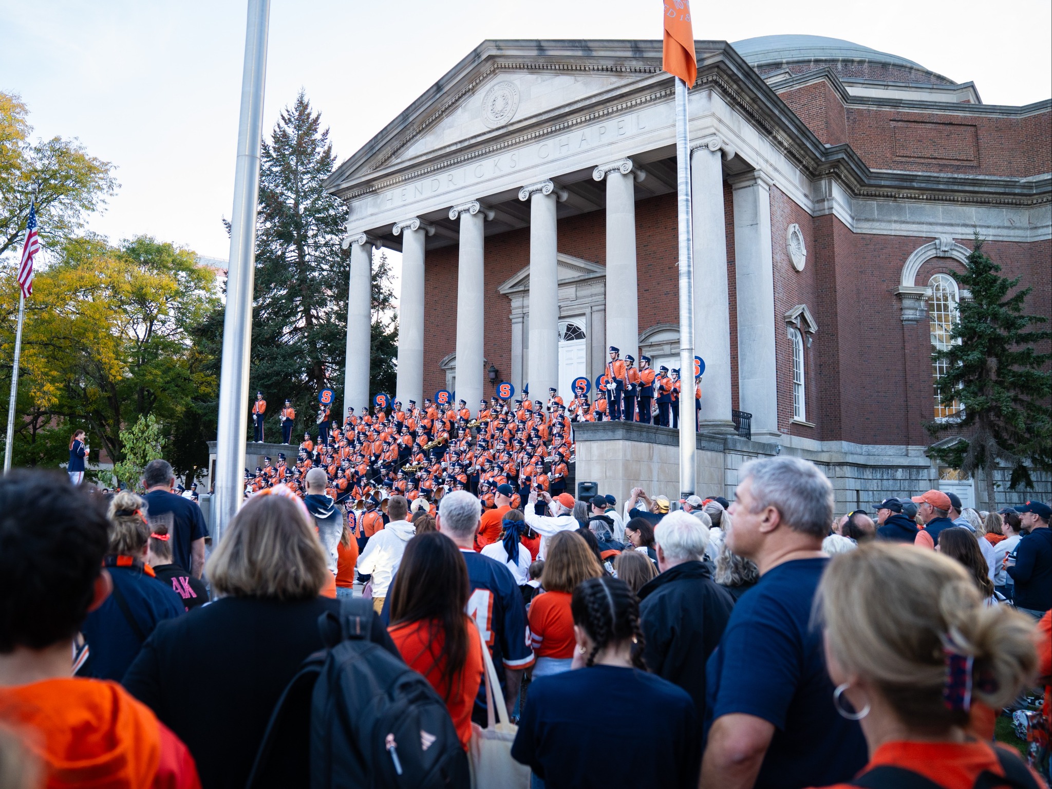 Crowd viewing marching band performance on Hendricks Chapel steps during evening Homecoming ceremony