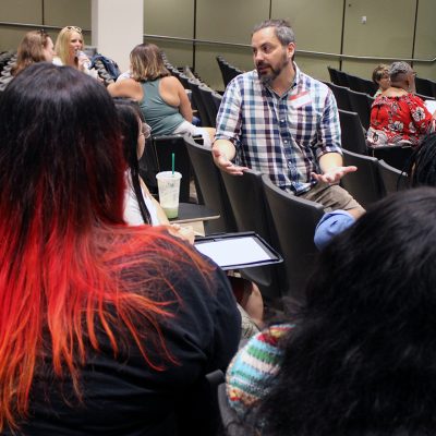 A professor chats with a group of teachers at a conference