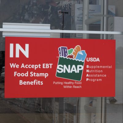 storefront entrance displaying sign that says "We Accept EBT Food Stamp Benefits" USDA SNAP (Supplemental Nutrition Assistance Program)"