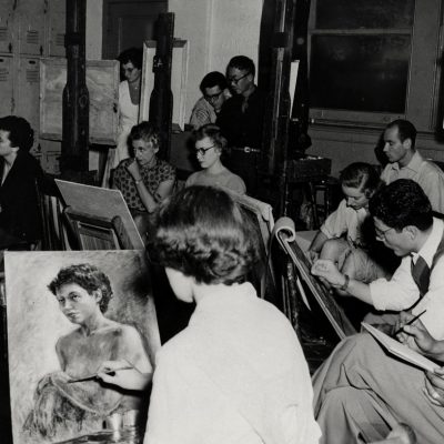 Art students seated at easels in a studio, each focused on drawing or painting.