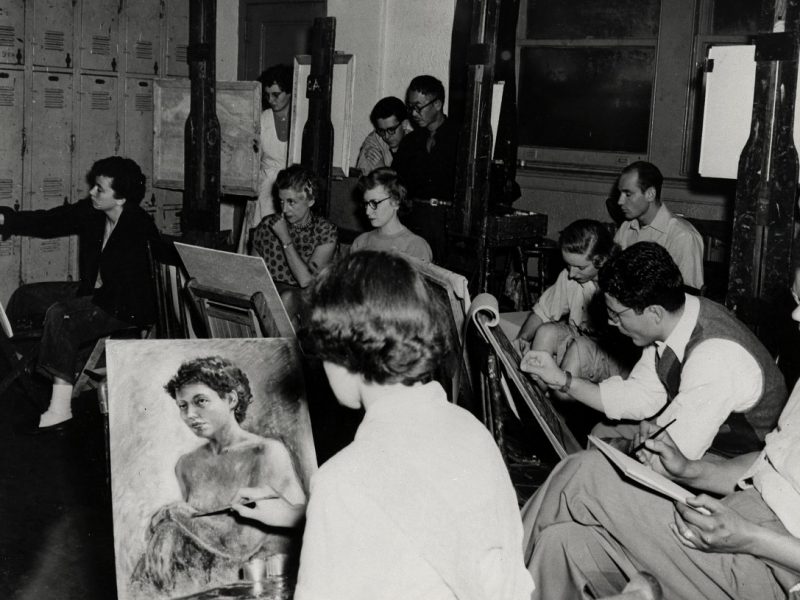 Art students seated at easels in a studio, each focused on drawing or painting.