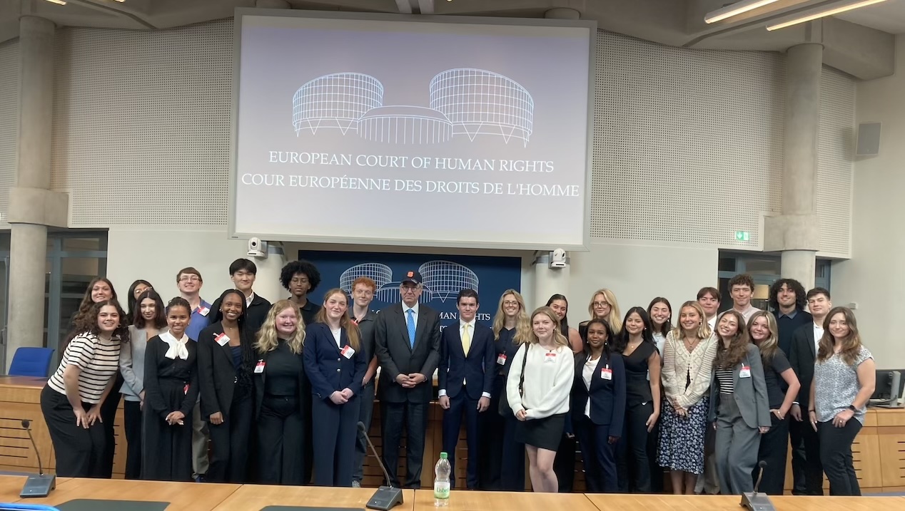 Group of students posing in a room at European Court of Human Rights.