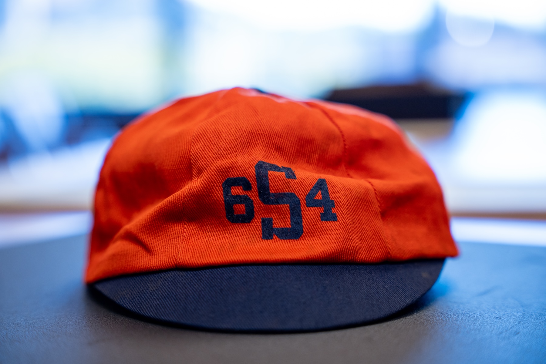 Vintage blue and orange university beanie with "6S4" printed on the front.
