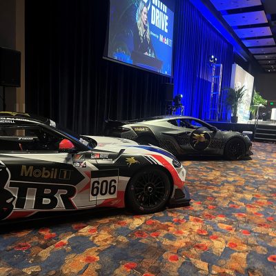Race cars sit next to a stage