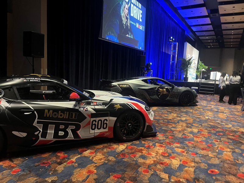 Race cars sit next to a stage
