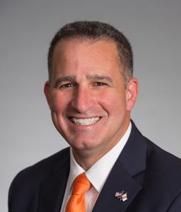 A person smiles for a headshot.