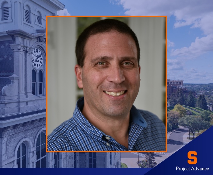Headshot of a person wearing a blue checkered shirt, framed by an orange border. The background features an image of a building with a clock tower on the left and a scenic view of trees and sky on the right. A blue banner at the bottom displays an orange “S” logo and the text “Project Advance.”
