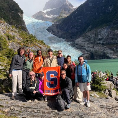 "Syracuse students with university flag at glacier lake in Patagonia, Chile.