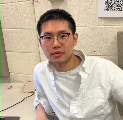 Dark-haired man, wearing glasses and white shirt