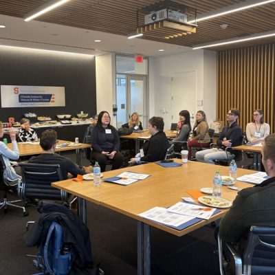 A group of professionals seated around conference tables during a Center for Health Behavior Research & Innovation meeting at Syracuse University's D'Aniello Institute for Veterans and Military Families.