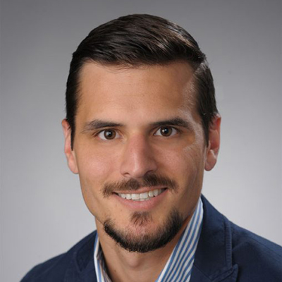 A person smiles while posing for a headshot.