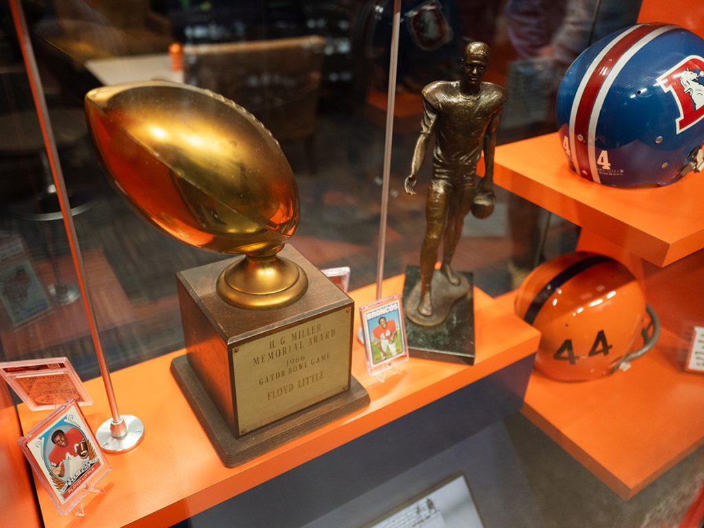 Artifacts included in the Legend of 44 exhibit, including helmets, a statue, an award and trading cards.