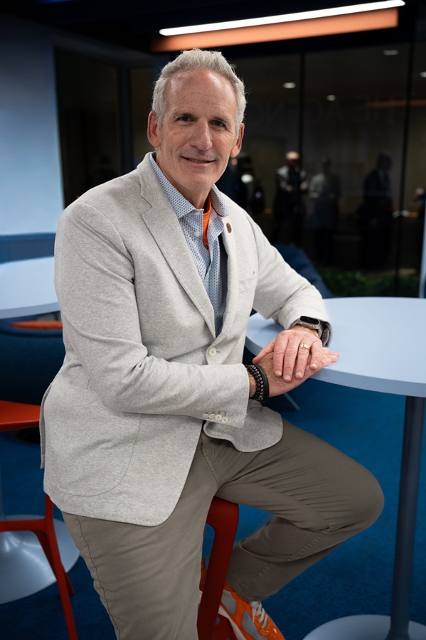person in sport coat sitting at a high table