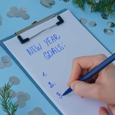 person writing down list of new year's goals