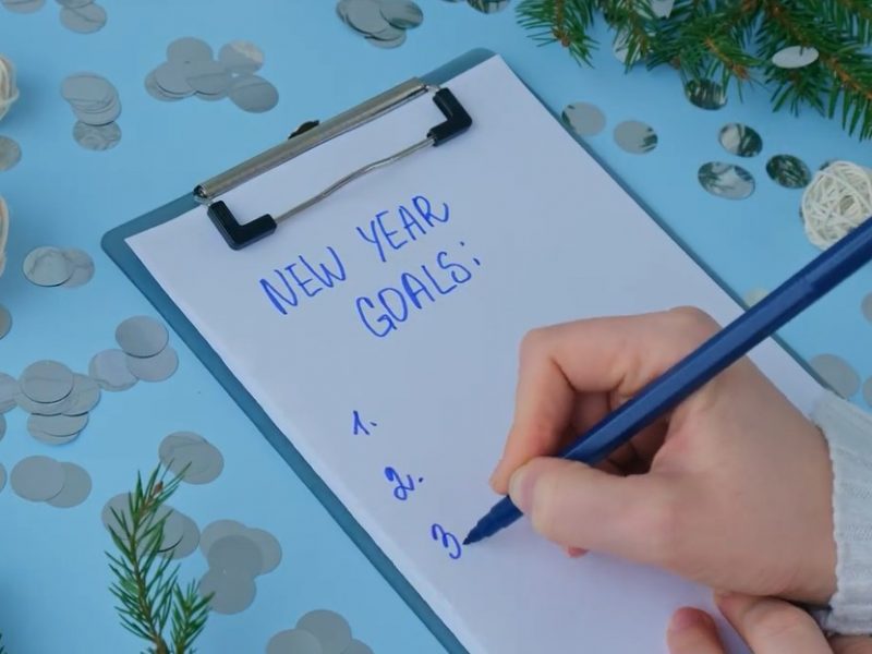 person writing down list of new year's goals