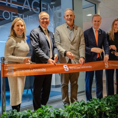 five people standing with scissors ready to cut a ribbon in front of the Weiss Center