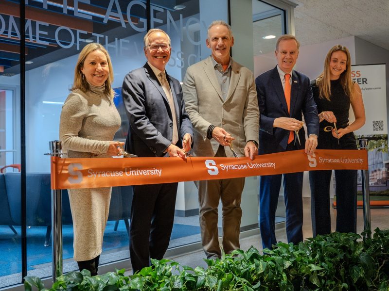 five people standing with scissors ready to cut a ribbon in front of the Weiss Center