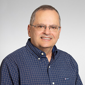Badi H. Baltagi, man smiling, wearing a blue shirt and glasses