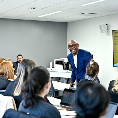 Guest lecturer speaking in front of a classroom.