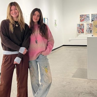 Two women standing in an art gallery