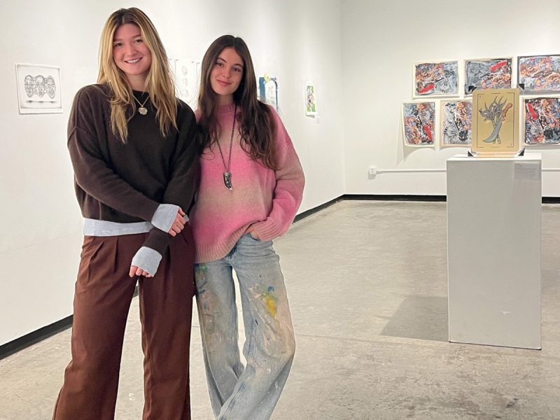 Two women standing in an art gallery