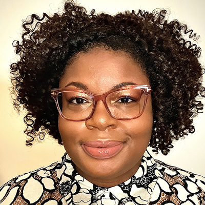 A person smiles while posing for a headshot.