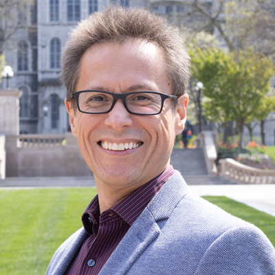 A person smiles while posing for a headshot.
