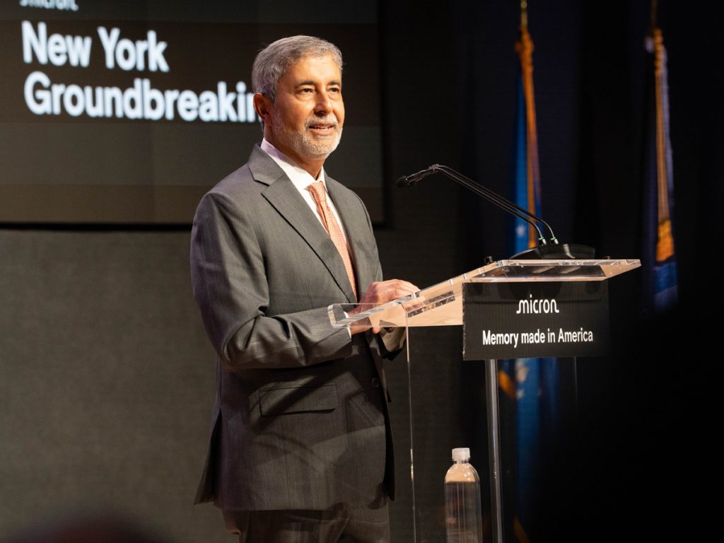 A person addresses a crowd while standing at a podium.