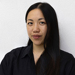 Woman with dark hair, wearing black blouse, smiling