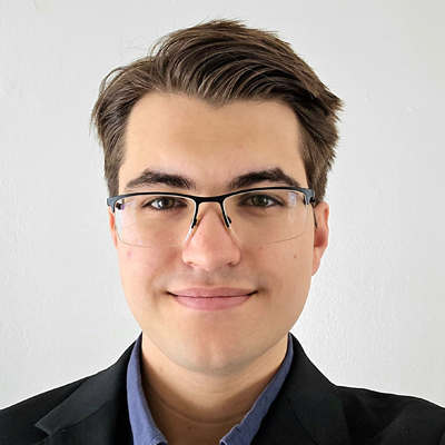 A student smiles while posing for a headshot indoors.