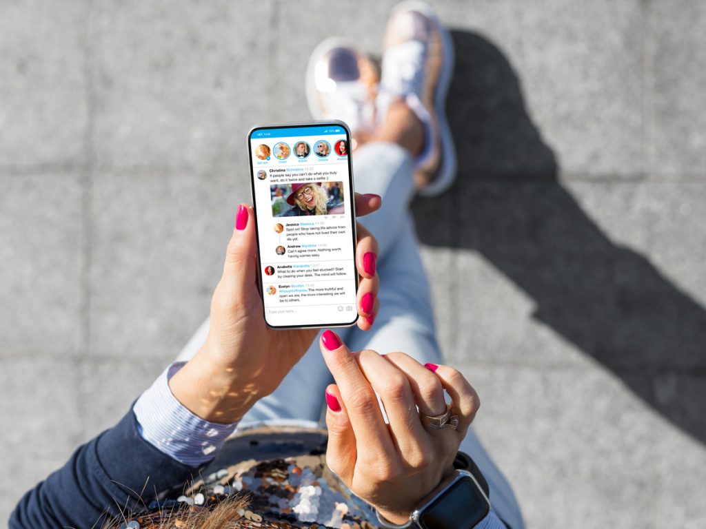 Person scrolling through social media feed on smartphone.