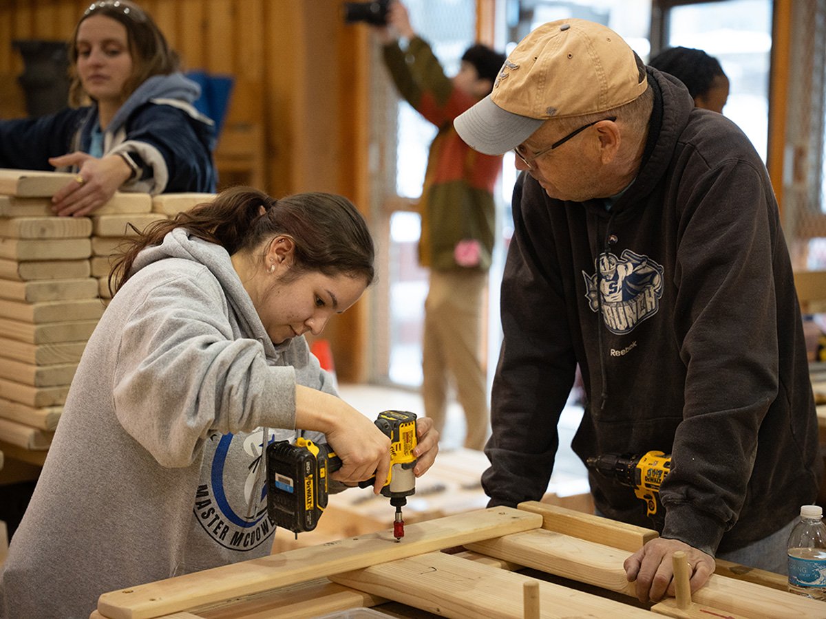 A student works on assembling a bed frame.