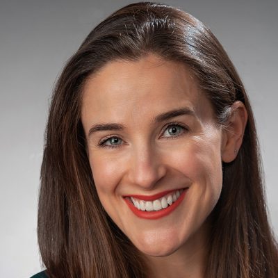Woman with long brown hair who is smiling.