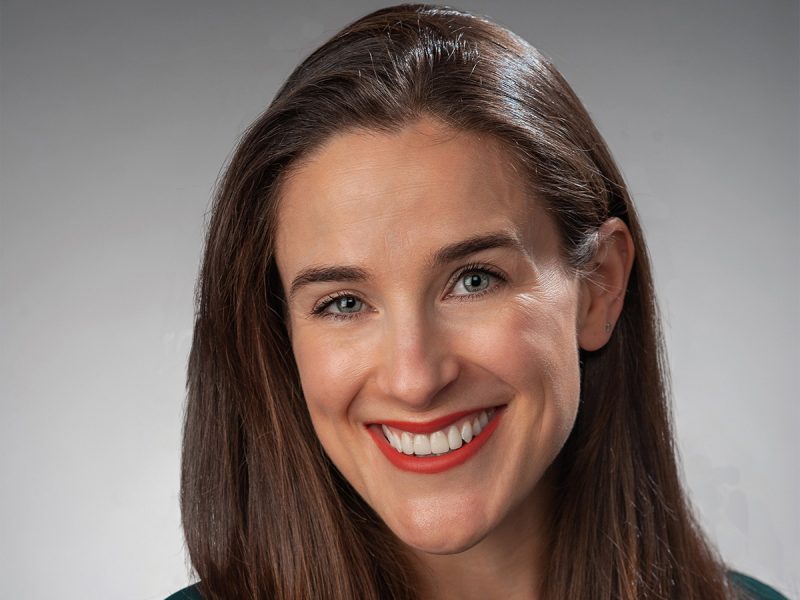 Woman with long brown hair who is smiling.