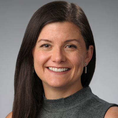 A person smiles while posing for a headshot.