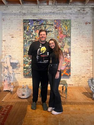 Man and woman standing in front of a piece of art