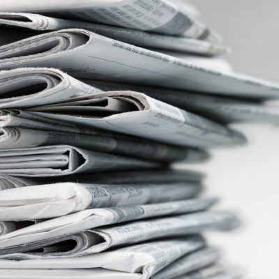 Stack of folded newspapers arranged in a neat pile