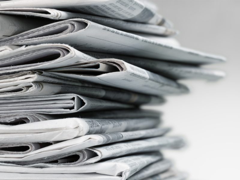 Stack of folded newspapers arranged in a neat pile