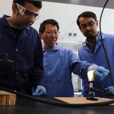 Laboratory team working together on a hands-on experiment at a workbench.