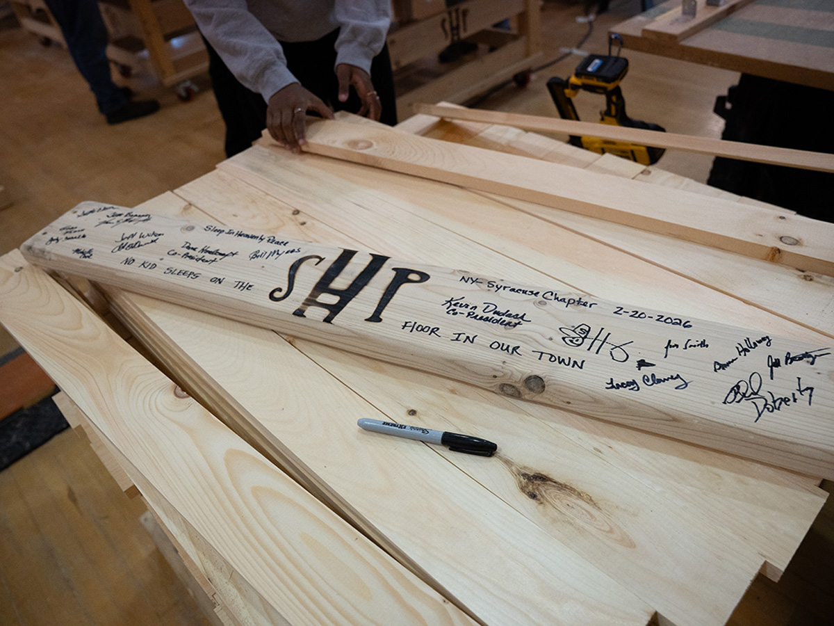 Board with the letters SHP is signed by volunteers.